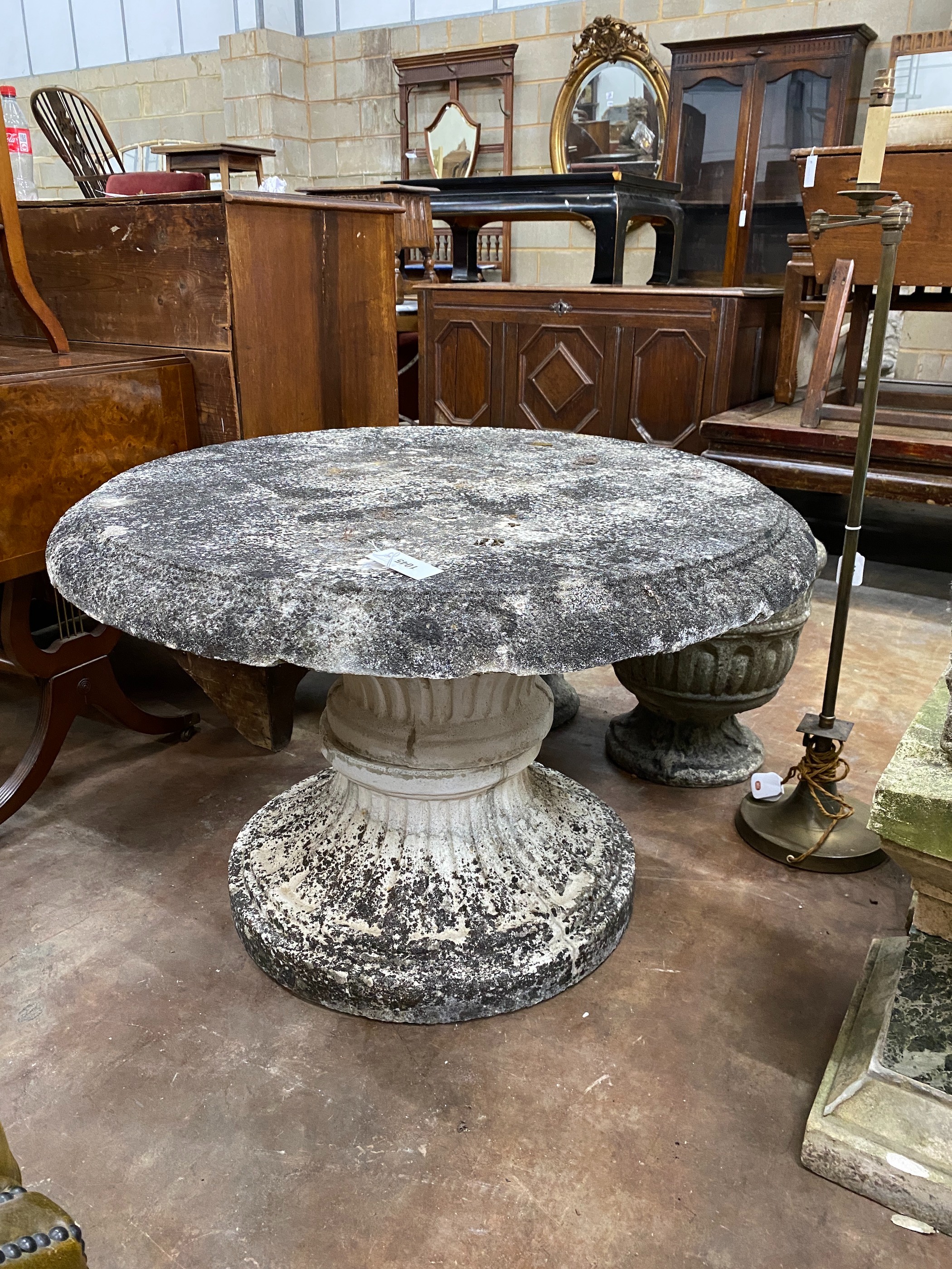 A circular reconstituted stone garden table, diameter 90cm, height 62cm